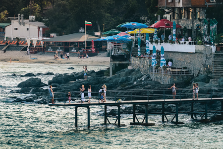 SOZOPOL, BULGARIA - JULY 27, 2011: Vacationers are photographed against the backdrop of the sea on a far-reaching pier in the resort town at sunsetのeditorial素材