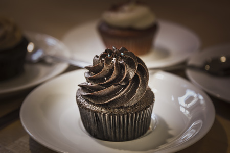 Muffin (cake) with chocolate cream on a white silver platterの写真素材