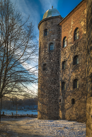 The castle wall and one of the towers of Vyborg Castle in the rays of the rising winter sunのeditorial素材