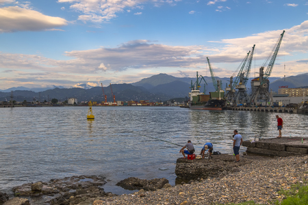 Batumi, Georgia - August 04, 2018: Batumi Sea Port with moored ships, port cranes and fishermenのeditorial素材