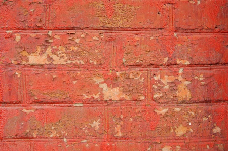 Brick wall with the remains of brown and red paint 