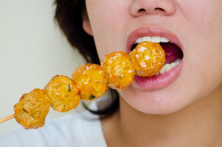 Woman eating deep fried crab meat roll Thai-Chinese food in thai call "HOY JOR"の写真素材