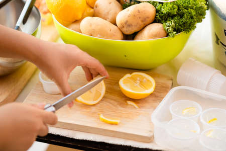 sliced lemons on a cutting board with knifeの写真素材