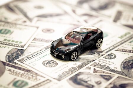 toy car over a dollar bills background with filter effect