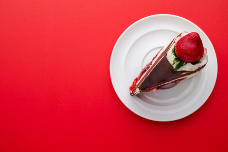 top view of Chocolate cake with strawberries on a red backgroundの写真素材