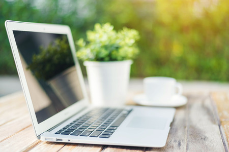 Laptop and coffee on wooden tableの写真素材
