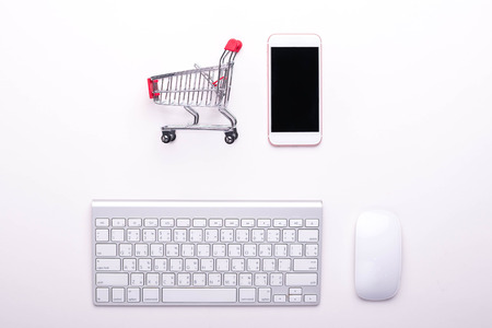 keyboard mouse smartphone and cart on the white background, online shopping conceptの写真素材