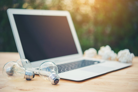 bulb and laptop onwooden table
