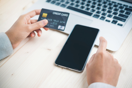 Online payment,hand using phone on worktableの写真素材