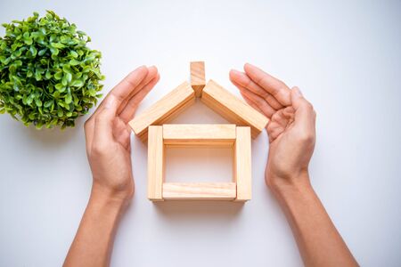 Hand arranging wood block as house. Real estate business concept.の写真素材