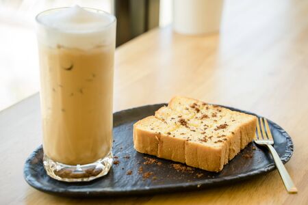 A baked bread served with a glass of iced coffeeの写真素材