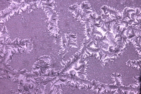 Frosty pattern on glass as a background, closeup of photo