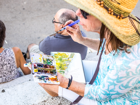 BARCELONA, SPAIN - JULY 10, 2015: An old woman is painting a beatiful watercolor scene in the National Palace surroundings.のeditorial素材