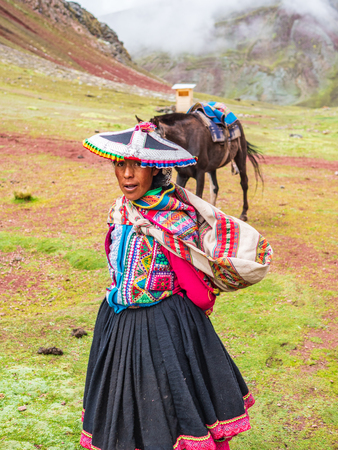 Vinicunca, Peru - January 7, 2017. View of a woman carrying a horse used for tourist transportation in the Vinicuca mountain.のeditorial素材
