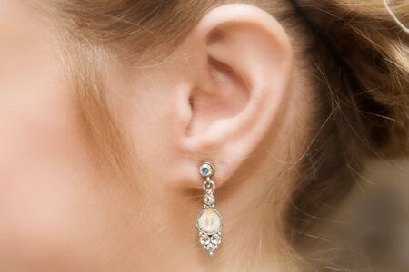 Close up of a brides ear with a pearl and diamond earringの写真素材