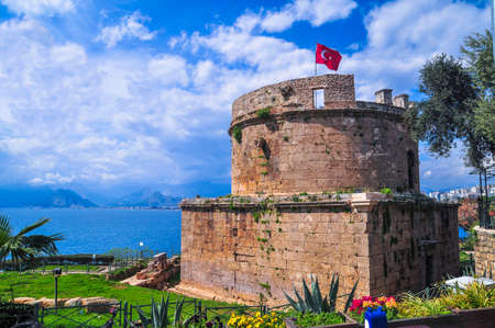 Old fort tower with flag of Turkey in Old Town Kaleici in Antalya.のeditorial素材