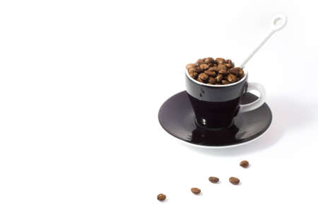 Espresso cup and saucer containing coffee beans isolated on white background with clipping pathの写真素材