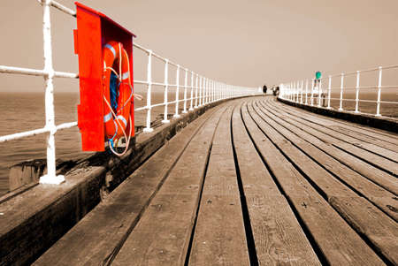 Whitby pier in sepia with red lifebeltの写真素材