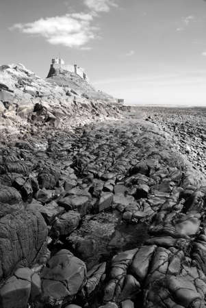 Black and white image of Lindisfarne Castle from beachの写真素材