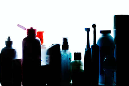 Beauty and hygiene products silouhetted on shelf of bathroom cabinetの写真素材