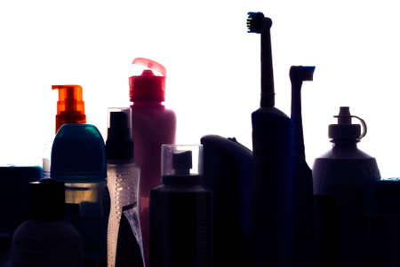 Beauty and hygiene products silouhetted on shelf of bathroom cabinet looking like a city skyline