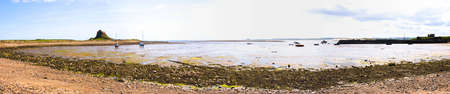 Panorama of Holy Island harbour and Lindisfarne Castle with tide outの写真素材