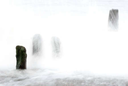 Waves washing over the groins at Sandsend, Whitby, North Yorkshire, England, UKの写真素材