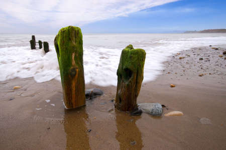 Waves washing over the groins at Sandsend, Whitby, North Yorkshire, England, UKの写真素材