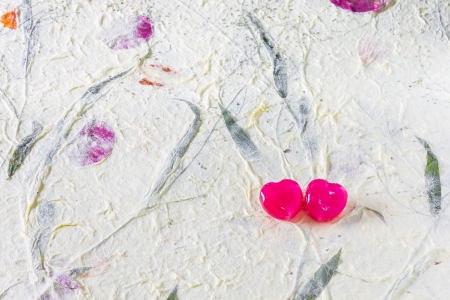 2 red heart candy on mulberry paper surface for sweet, love, romance, classic work  Pastel color backgroundの写真素材