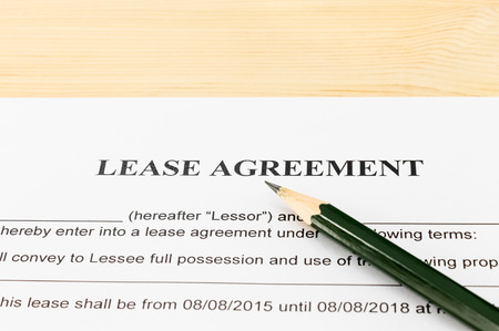 Lease Agreement Contract Document and Pencil Horizontal View on Wood Table in Vintage Style. Legal document for business eventの写真素材