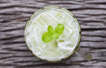 Cold Green Tea Milk Beverage or Cold Drinks Flatlay Center Frame. Green cold drinks and ice on wood table for drinkの写真素材