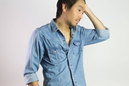 Portrait Man in Jeans Shirt or Denim Shirt Fashion Swing Hair Up Pose. Jeans shirt or denim shirt fashion for men on grey backgroundの写真素材