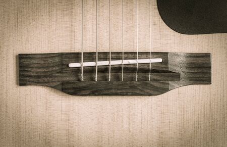 Wood Bridge and Plastic Saddle and String and Pick-guard of Acoustic Guitar in Natural Lightの写真素材