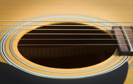 Sound Hole and Acoustic Guitar String and Pick guard and Fingerboard and Fret in Close Up Viewの写真素材