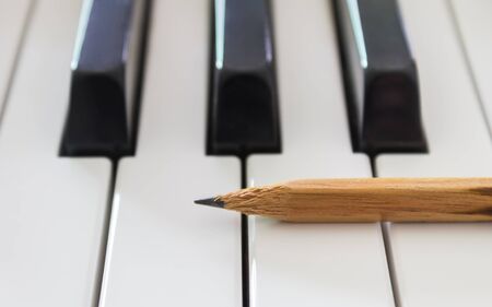 Old Pencil on White Keys of Electric Piano in Horizontal View. Concept about Piano Playing or Piano Learningの写真素材