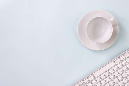 Coffee Cup and Pen and Computer Keyboard on Modern Clean Creative Office Desk or Office Table on Top View or Flat Lay. Blue Workspace Minimalist Background and Office Suppliesの写真素材