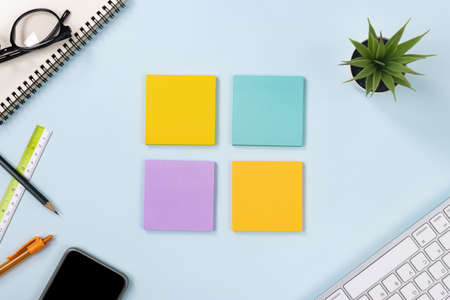 4 Sticky Note or Note Pad and Office Supplies as Keyboard,Pen,Pencil,Office Plants,Spiral Notebook,Glasses,Ruler,Mobile Phone on Modern Clean Creative Office Desk or Table on Top View or Flat Layの写真素材