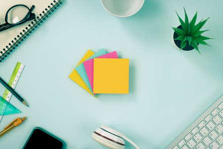 4 Color Stick Note or Note Pad and Office Supplies as Keyboard,Pen,Pencil,Office Plants,Notebook,Glasses,Smartphone,Headphone,Coffee Cup on Top View Office Desk in Vintage Toneの写真素材