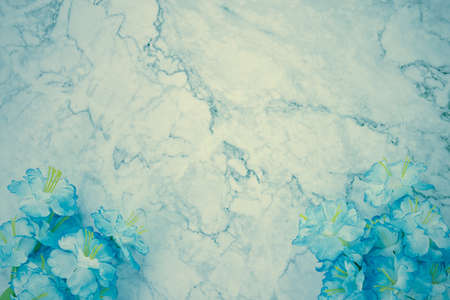 Modern Clean Flat Lay or Top View Office Desk or Office Table and Blue Flower at Bottom on Marble Minimalist Background in Vintage Toneの写真素材