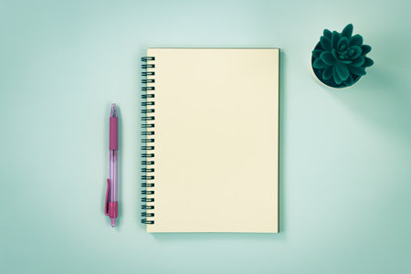 Spiral Notebook or Spring Notebook in Unlined Type and Pen and Office Plant on Blue Pastel Minimalist Background in Vintage Toneの写真素材