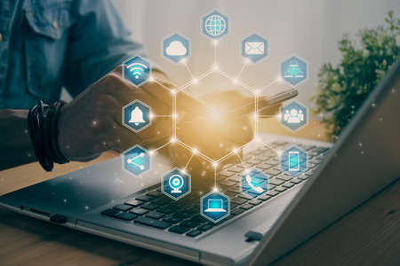 Casual Businessman Touching Smart Phone or Mobile Phone Screen by Finger on Laptop Computer and Blue Hexagonal Social Communication Sign Search Icon,Position Pin,Wifi,Cloud in Vintage Toneの写真素材