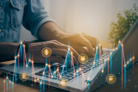Casual Businessman Hand Using and Typing Laptop Computer with Color Currency Stock or Forex Market Bar Chart and Line Graph Trend. Financial Economy and Business Growth Concept in Vintage Toneの写真素材