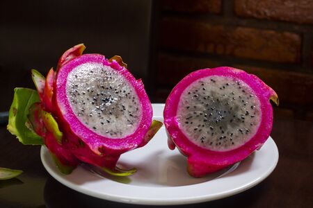 Dragon fruit or pitaya fruit Hylocereus undatus. Sectional view on a wooden background. Tropical, exotic pitaya fruit.の写真素材