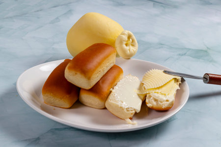 Some dinner rolls in Brazil are called Bisnaguinha filled with cheese and cream cheese on a white...