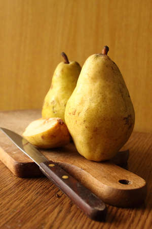 Two pears with light wood background and knife.Natural.の写真素材