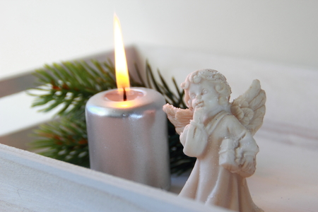 Silver candle and angel with wood bacground.の写真素材
