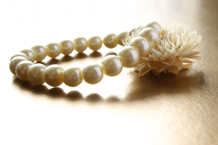 Elegant pearl bracelet with flower in soft light opposite. High key exposition.の写真素材
