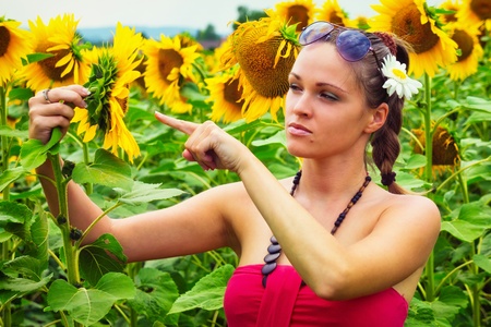 Beautiful young woman between sunflowersの写真素材