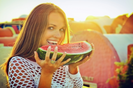 Beautiful young woman eating a watermelon on her holidaysの写真素材