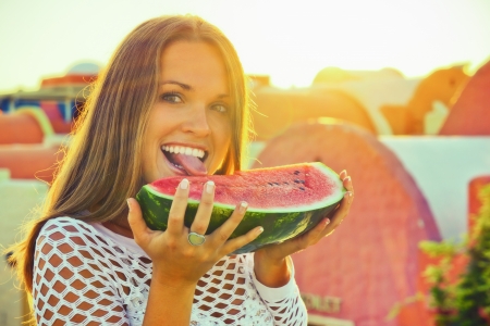 Beautiful young woman eating a watermelon on her holidaysの写真素材